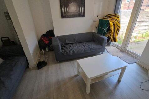 A compact living room with modern light wood fl...