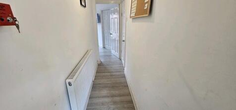 A clean and simple hallway featuring light wood...