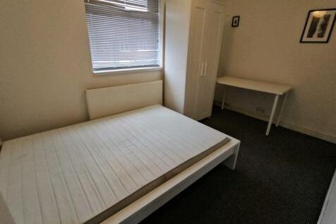 A simple, clean single bedroom featuring a whit...