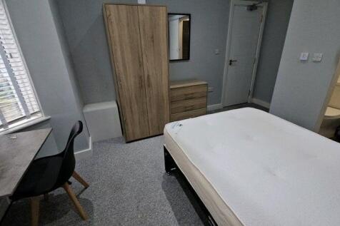 A cozy double bedroom featuring a large window ...