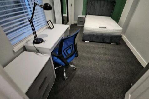A tidy single bedroom featuring a comfortable b...