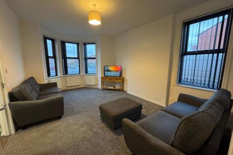 A spacious and tidy living room featuring two c...