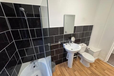 A modern bathroom suite featuring a white batht...