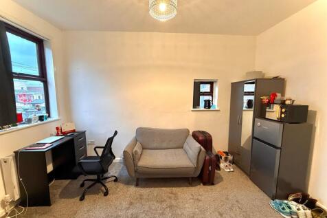 A well-maintained living room featuring cozy gr...