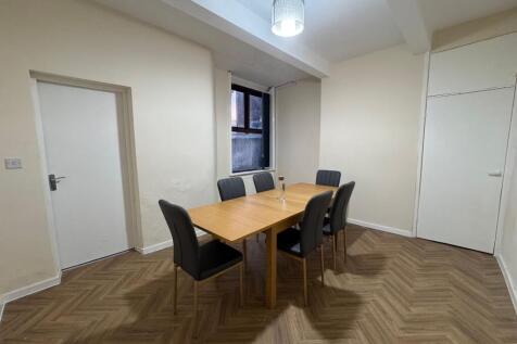 A neat, modern communal workspace featuring a w...