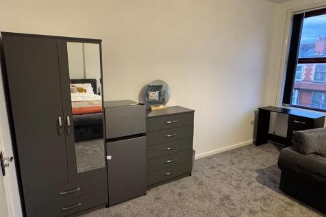 A spacious master bedroom featuring modern dark...
