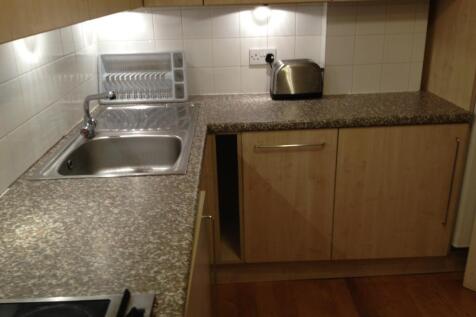A compact and tidy kitchen featuring wood-effec...