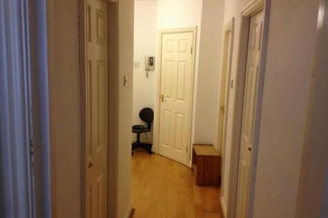 A clean and simple hallway with light wooden fl...