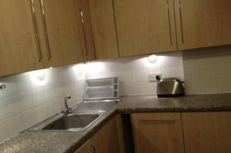 A compact and tidy kitchen featuring modern woo...