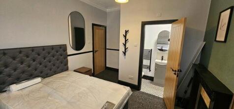 A cozy master bedroom featuring a comfortable d...