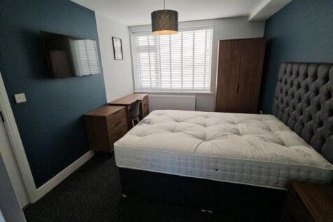A stylish master bedroom featuring a comfortabl...