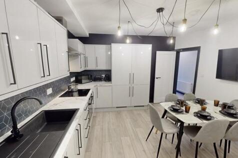 Modern kitchen with sleek white cabinetry, a sp...