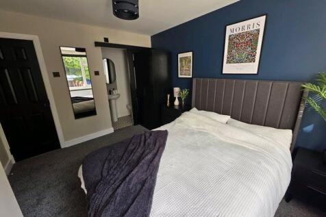 A stylish master bedroom featuring a comfortabl...