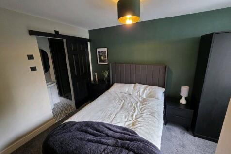 A stylish master bedroom featuring a comfortabl...