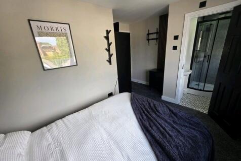 A modern double bedroom featuring a neatly made...