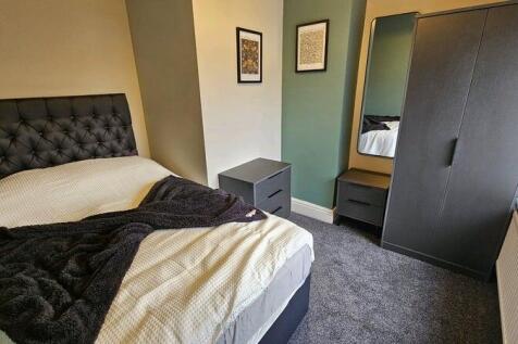 A cozy double bedroom featuring a stylish tufte...