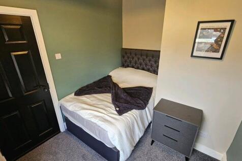 A cozy and well-kept single bedroom featuring a...