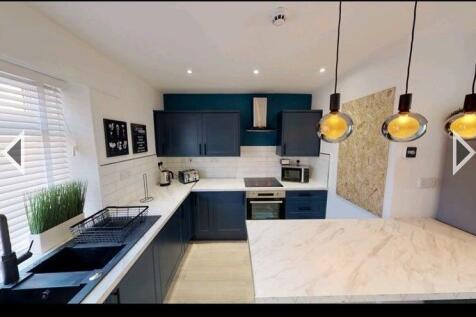 A modern, stylish kitchen featuring sleek navy ...