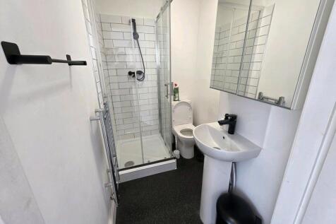 A clean and modern bathroom featuring a glass-e...