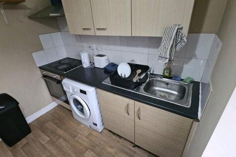 Compact kitchen area featuring modern appliance...