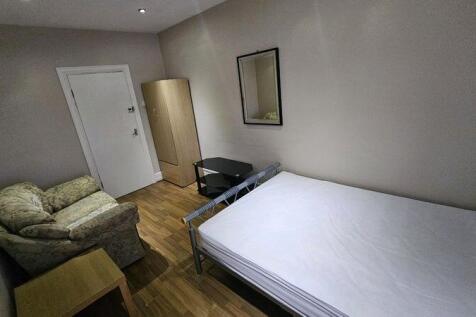 A tidy single bedroom featuring a comfortable a...