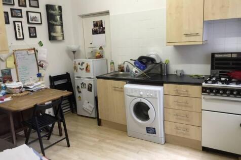 A compact kitchen featuring light wooden cabine...