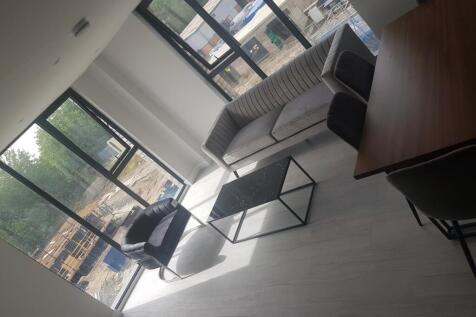 Bright and modern living room featuring large w...