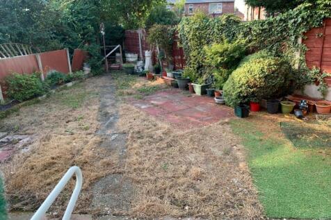 A spacious garden area with a mix of grass and ...
