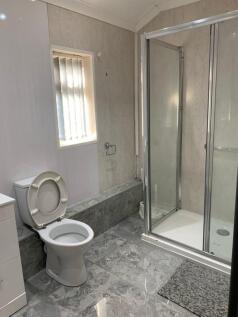 A modern bathroom featuring a glass-enclosed sh...