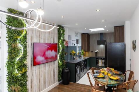 A modern, stylish kitchen featuring sleek black...