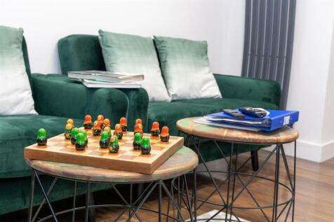 A stylish living area featuring a dark green so...