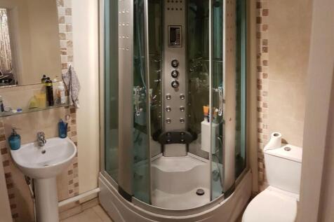 A modern bathroom featuring a large shower encl...