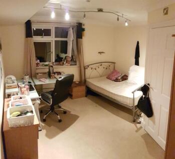 A neat and functional bedroom featuring a singl...