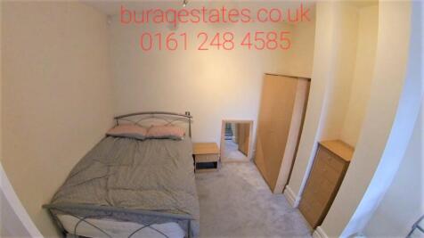 Cozy single bedroom featuring a neat bed with w...