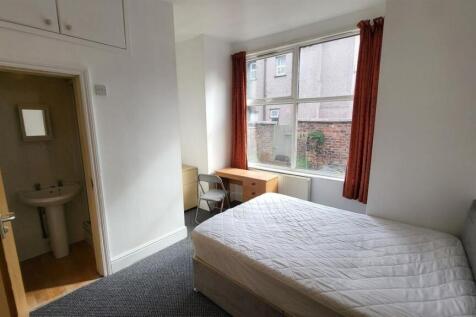 Bright double bedroom featuring a large window ...