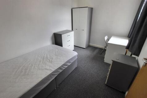 A simple and tidy single bedroom featuring a cl...