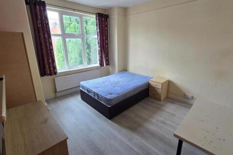 A bright double bedroom featuring a large windo...