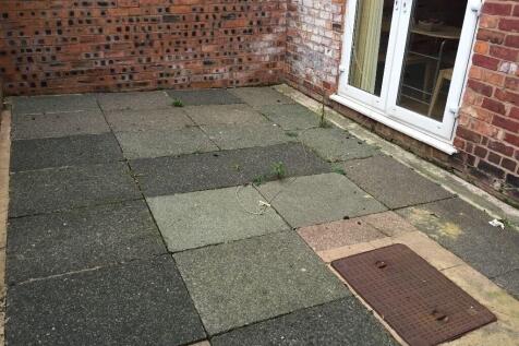 A modest private outdoor garden area with paved...