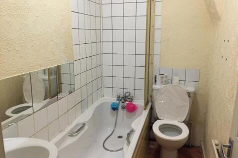 A compact bathroom with a full-sized bathtub fe...