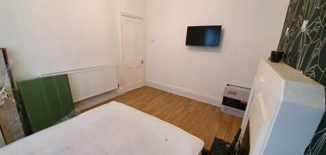 A simple double bedroom with wooden flooring, n...