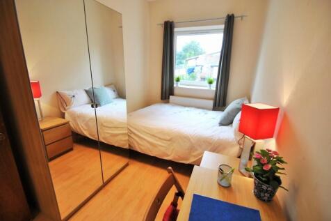 A bright and cozy bedroom featuring a neatly ma...