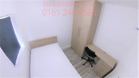 A compact, neat bedroom featuring a single bed,...