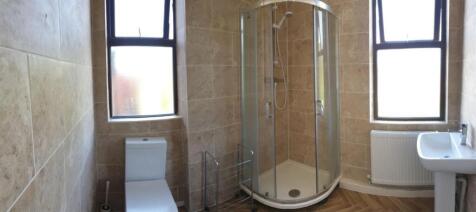 A bright and clean bathroom featuring stone-til...