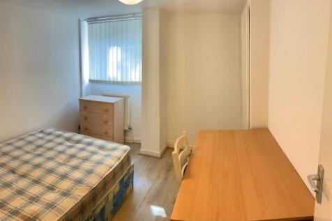 A neat and tidy single bedroom featuring a comf...