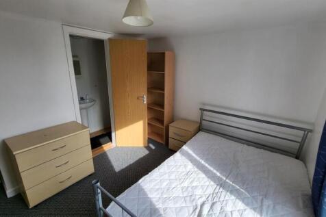 A bright double bedroom featuring a metal frame...