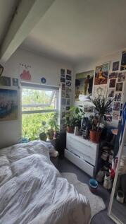 A cozy single bedroom with a bright window over...
