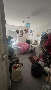 A cozy bedroom space featuring a single bed wit...