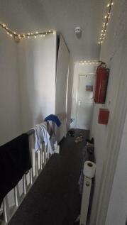 A narrow hallway featuring white walls decorate...