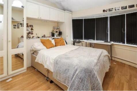 A cozy double bedroom featuring large windows t...