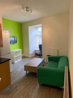 A cozy living room featuring a bright green sof...